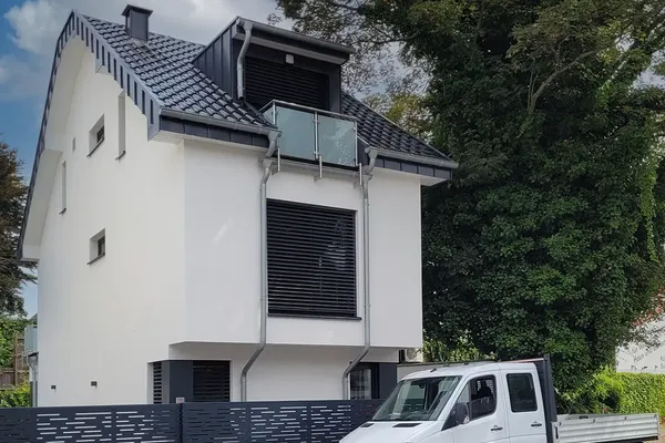 Neubau eines Einfamilienhauses in Köln Weiden mit moderner Fassade und Glasbalkon – Bauausführung durch Bytyqi Bau.
