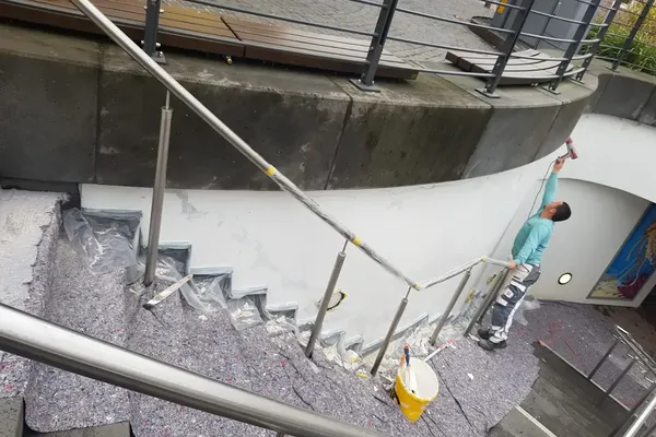 Detailgenaue Malerarbeiten an der Rundwand des Bahnhofs Bad Breisig: Renovierung für einheitliche Optik und Schutz der Bausubstanz.