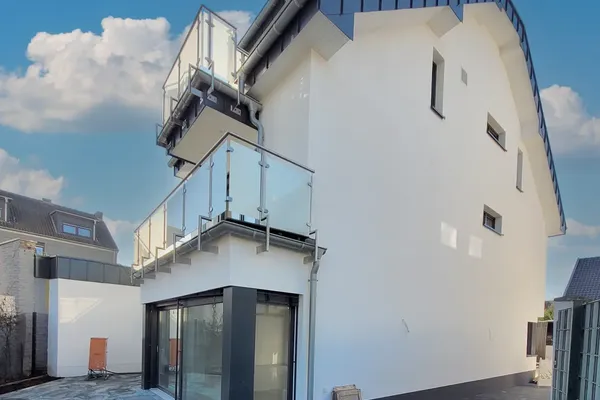 Hochwertiger Neubau eines 1-Familienhauses in Köln Weiden – moderne Architektur mit Glasbalkon, realisiert durch Bytyqi Bau.